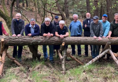 Members of the Men's Shed team with the log used to create a totem pole