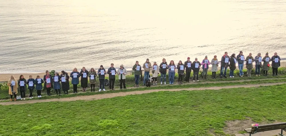 30 representatives of the Homelessness Partnership BCP at Bournemouth beach, each representing five children spending Christmas in B&Bs